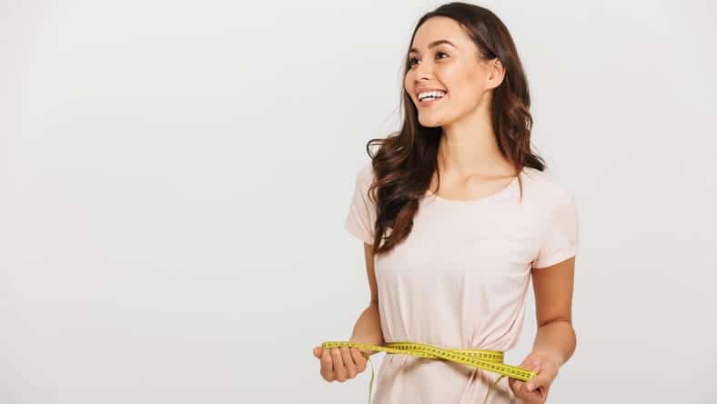 Woman holding a tape measure around her waist