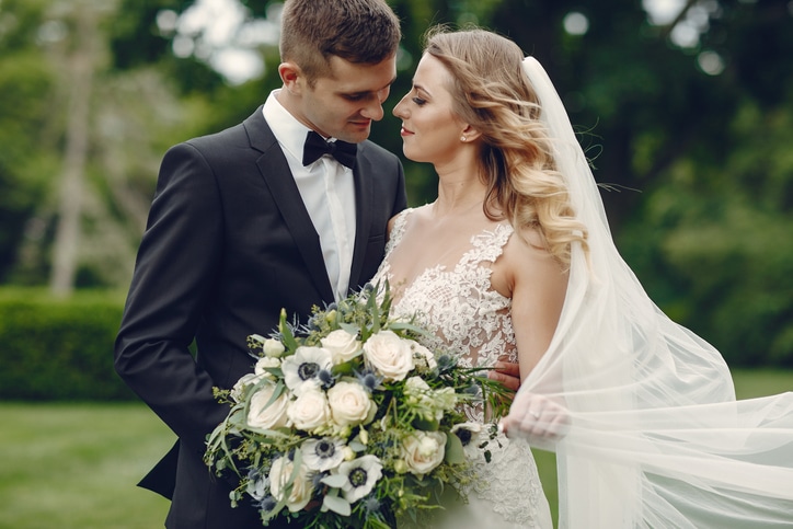 Beautiful bride in a long white dress. Handsome groom in a black suit.