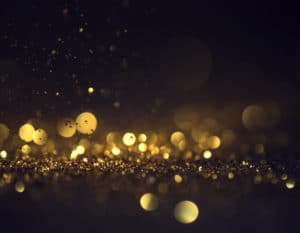 A close up of glittery gold material on a black background