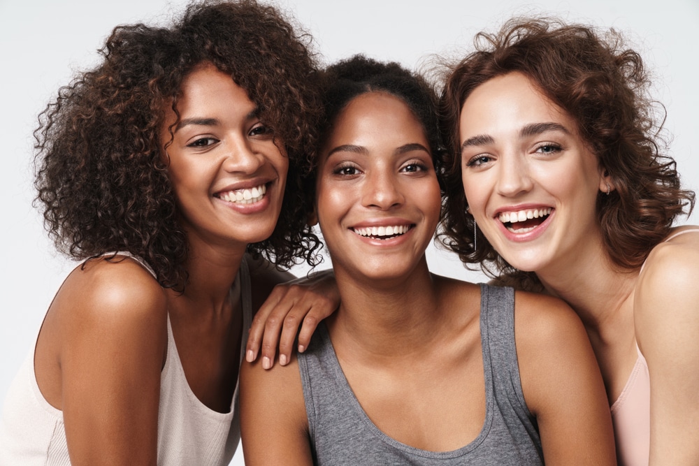 Three young women smiling at the camera together