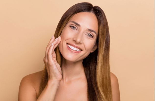 Portrait of attractive cheery long-haired woman touching soft skin