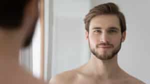 Headshot of handsome man with beard who has newly clear skin