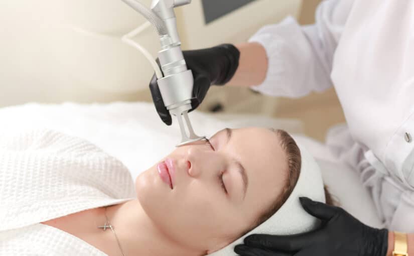 Relaxed looking woman getting laser skin resurfacing on her face to treat crepey skin and fine lines.